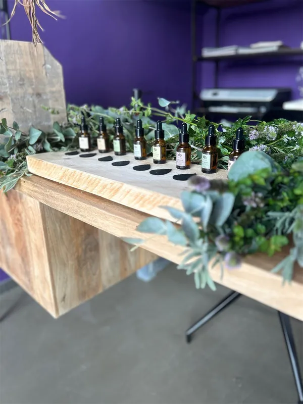Duftbar mit Ölfläschchen und Grün an einem Stand